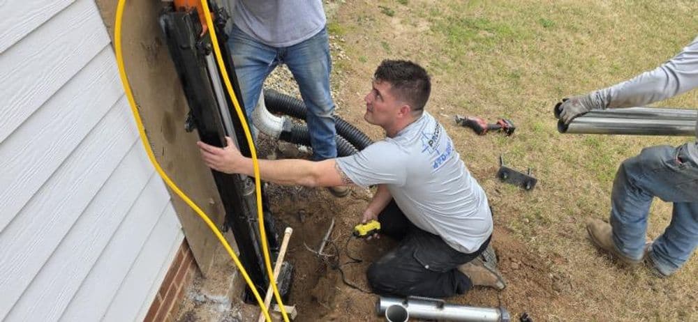 Workers installing a trenchless sewer line, focusing on equipment and teamwork outdoors.