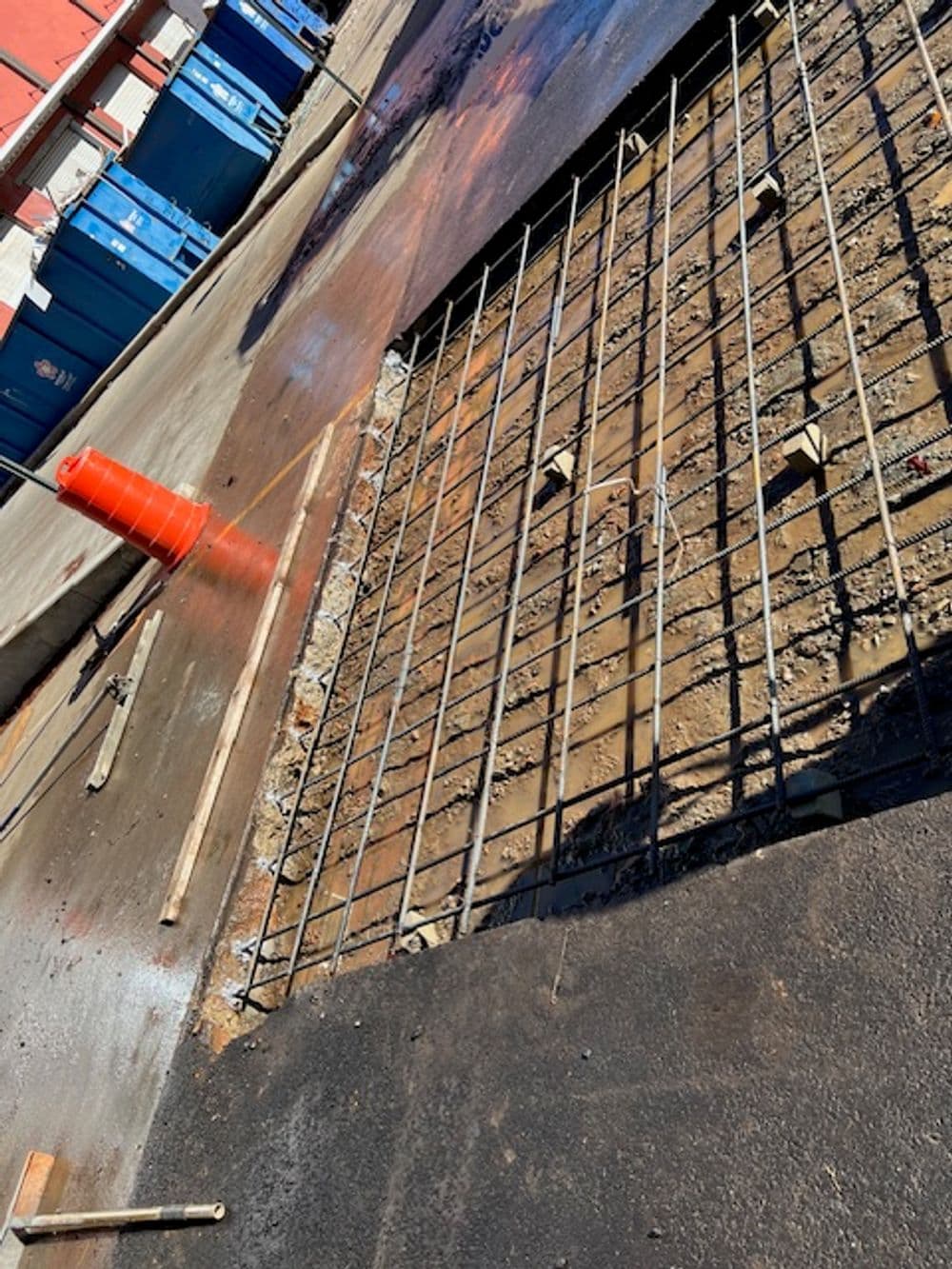 Construction site with reinforced rebar framework on freshly poured concrete.