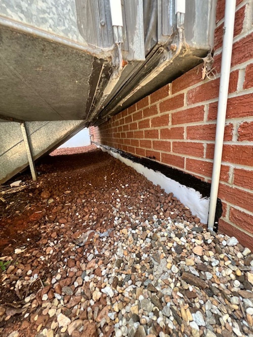 Drainage system under building with gravel, preventing moisture damage to foundation.
